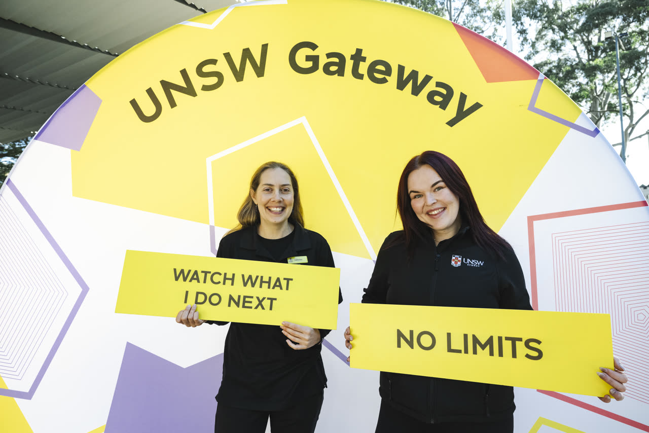 Students holding UNSW Gateway signs at a campus event