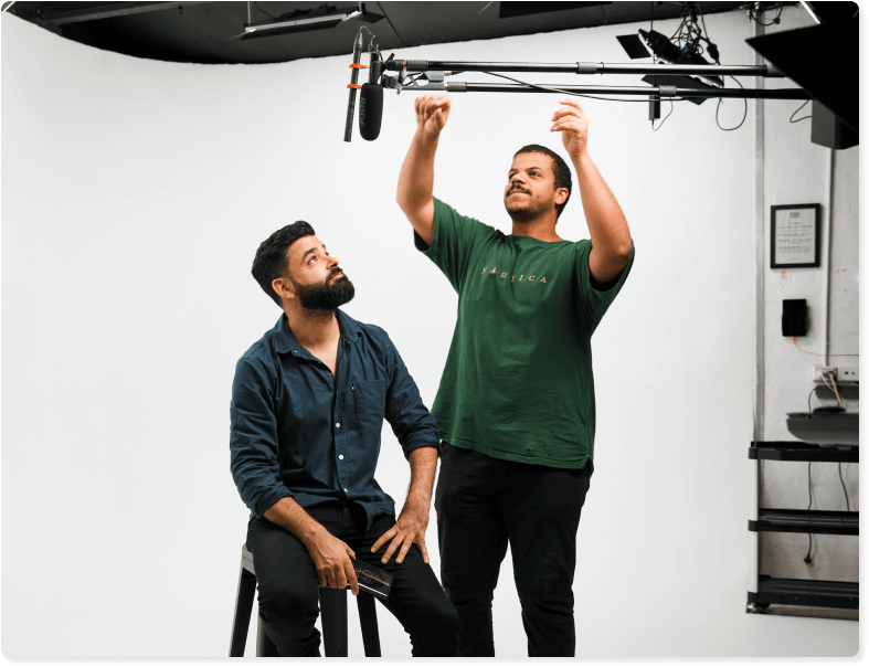 A producer adjusts a boom microphone at a professional shoot